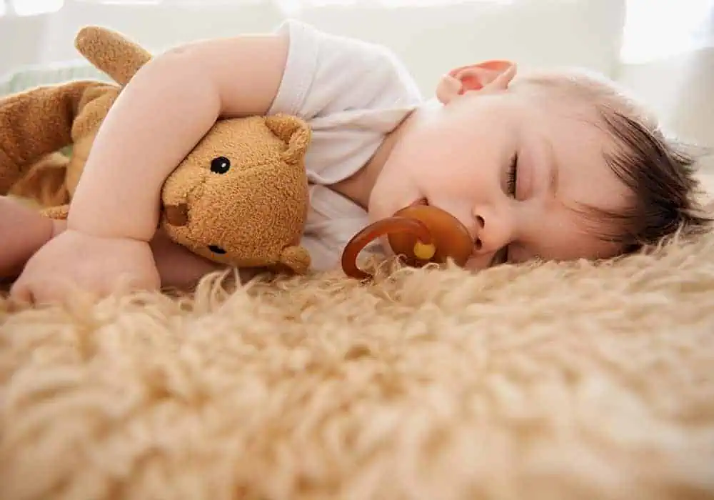 Baby sleeping peacefully on a carpet with underlay underneath