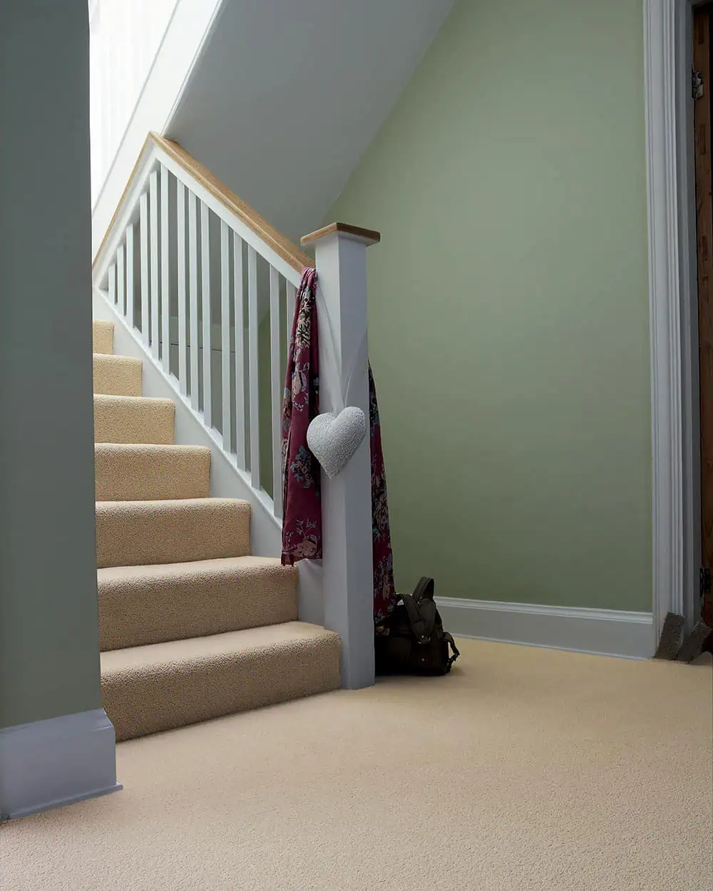 A beige carpet installed on stairs and landing over underlay