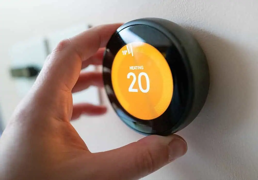 Man turning down a smart thermostat