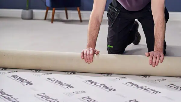 Man laying Tredaire underlay with the branding facing up