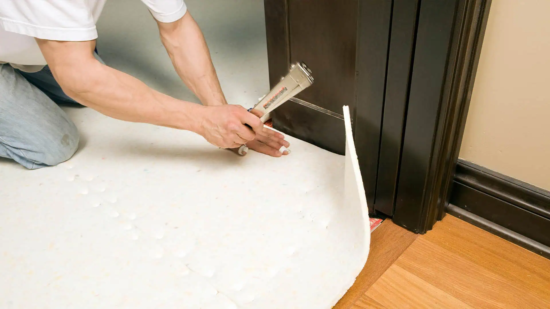 Man installing foam carpet underlay