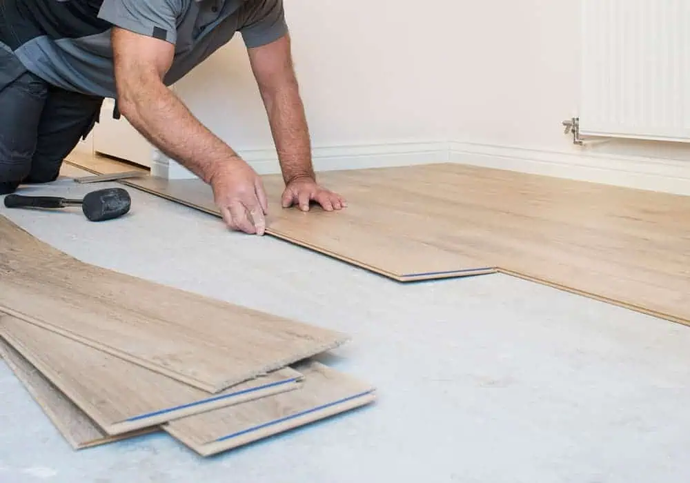 Man installing laminate flooring without underlay