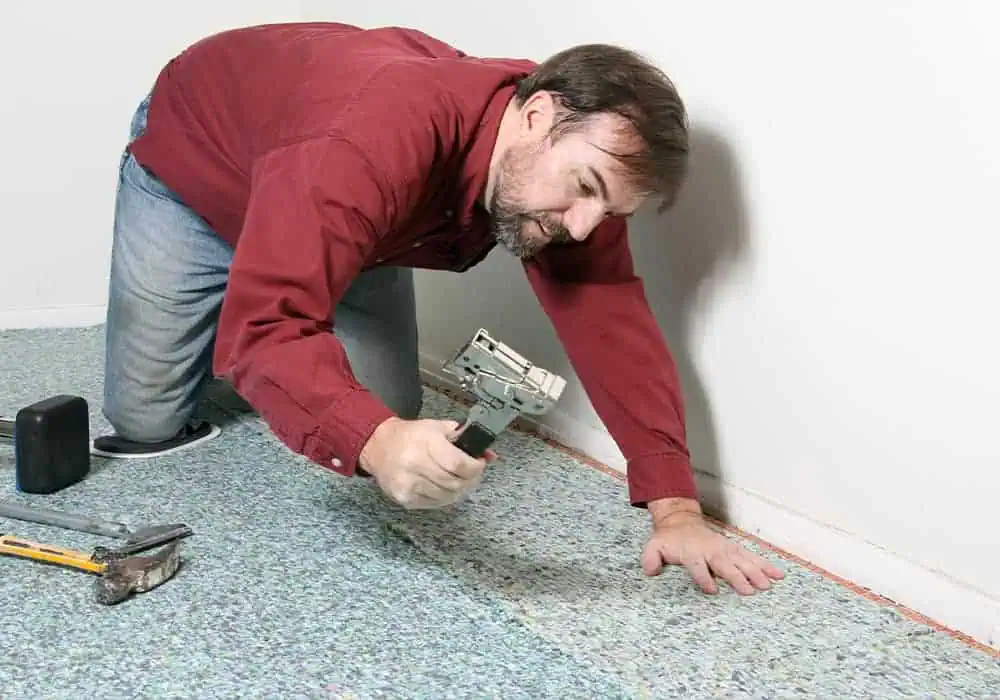 Man stapling carpet underlay using a staple gun