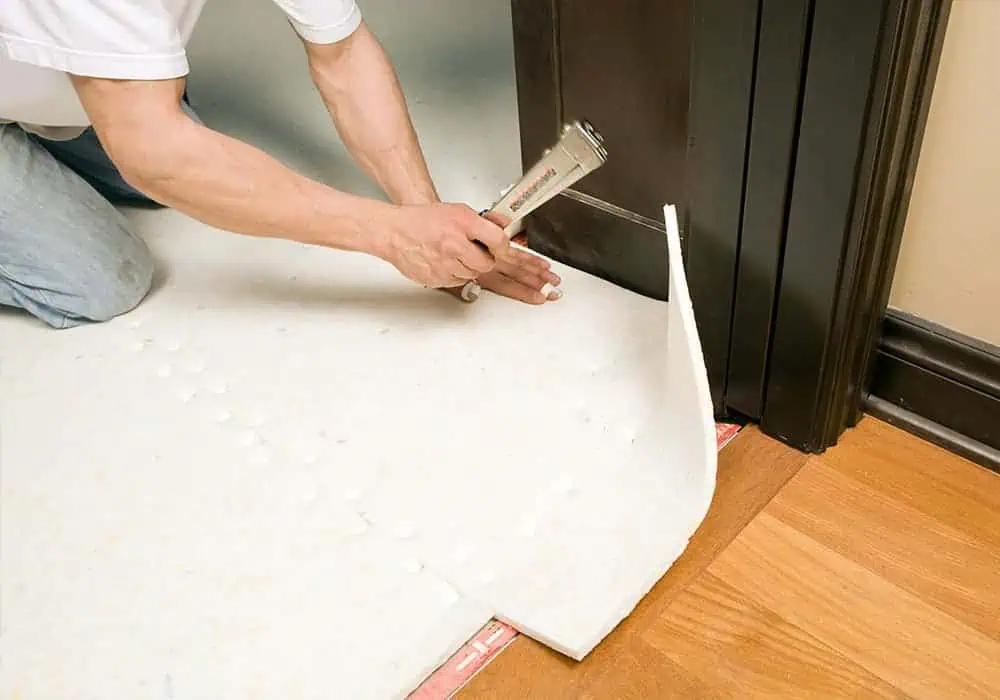 Man installing carpet underlay in a doorway