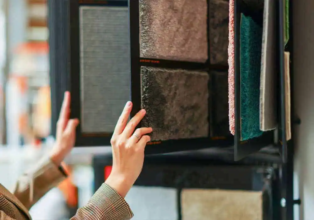 Woman browsing different types of carpets in a store