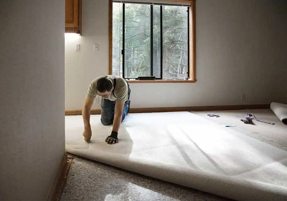 Carpet fitter installing a room carpet