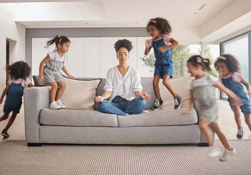 Woman sitting on sofa with kids making a lot of noise