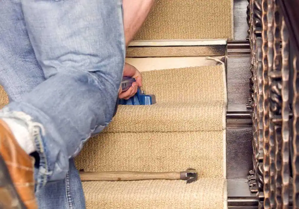 Carpet fitter installing a stair runner