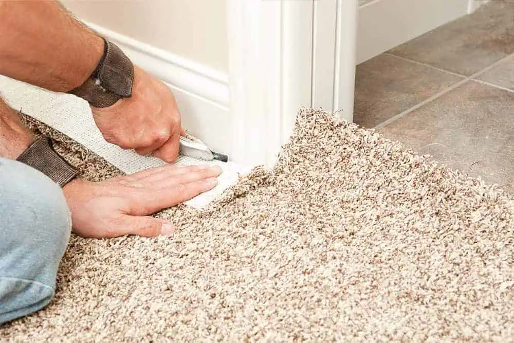 Carpet fitter cutting a carpet around a doorway opening