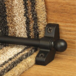 Jubilee Black Stair Carpet Runner Rod in Black installed on wooden stairs with striped runner