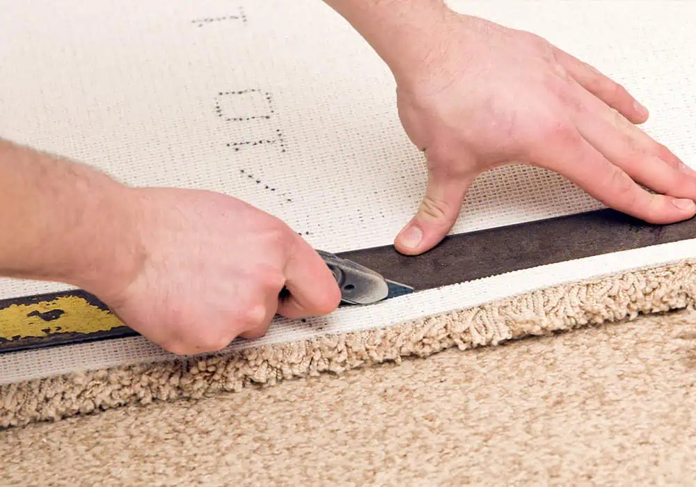 Man cutting carpet ready to install on stairs