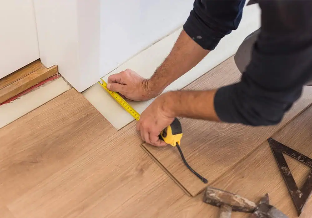 Man measuring a corner cut on laminate flooring