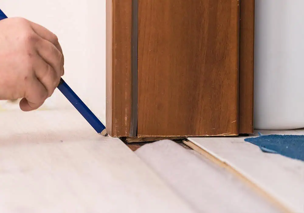 Laying laminate flooring underneath a doorframe