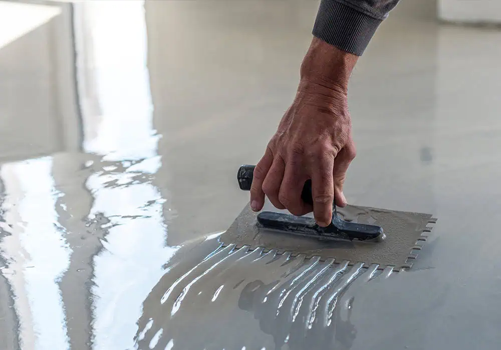 Man applying self levelling compound to a floor