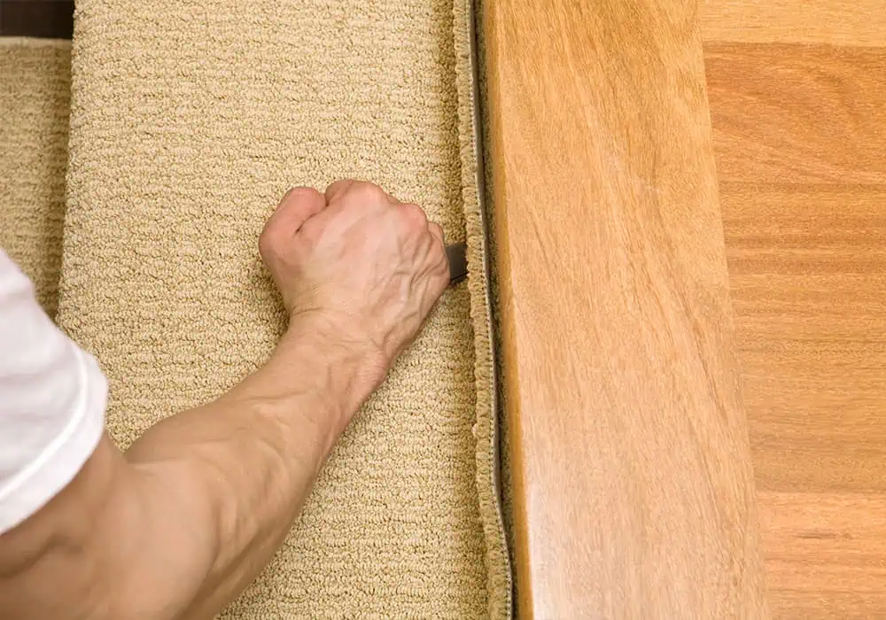 Man fitting the top step of a carpet runner