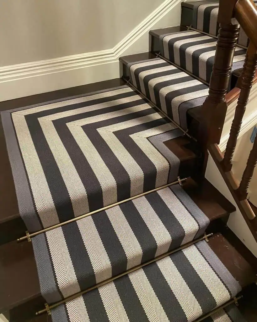 Wide striped carpet runner with solid brass stair rods