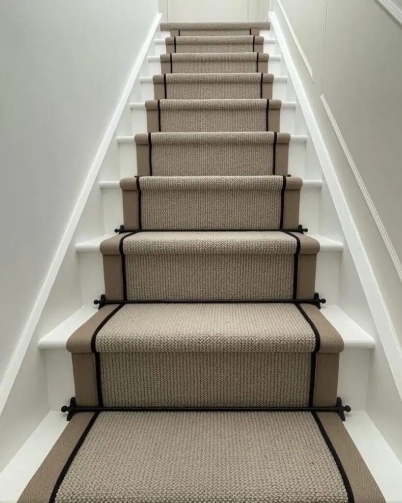 Black stair rods installed with a textured carpet runner