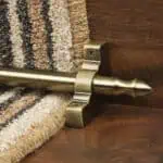 Homepride Stair Carpet Runner Rod in Antique Brass with a striped carpet on wooden stairs