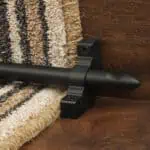 Homepride Stair Carpet Runner Rod in Black with a striped carpet on wooden stairs