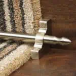 Homepride Stair Carpet Runner Rod in Satin Nickel with a striped carpet on wooden stairs